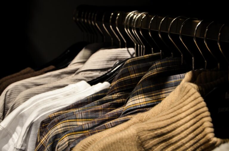 Black clothes hangers displaying garments